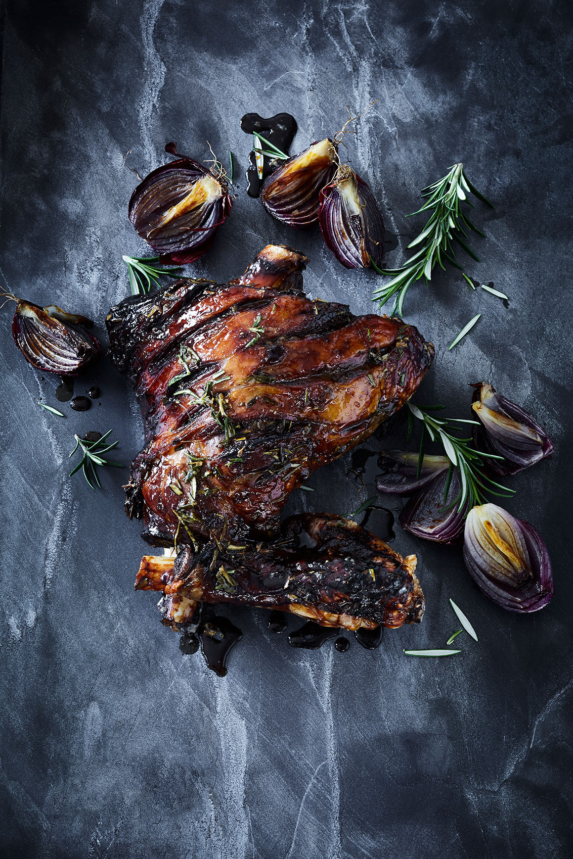 Honey Lamb Leg with Rosemary on Dark Stone Bench • Advertising & Editorial Food Photography