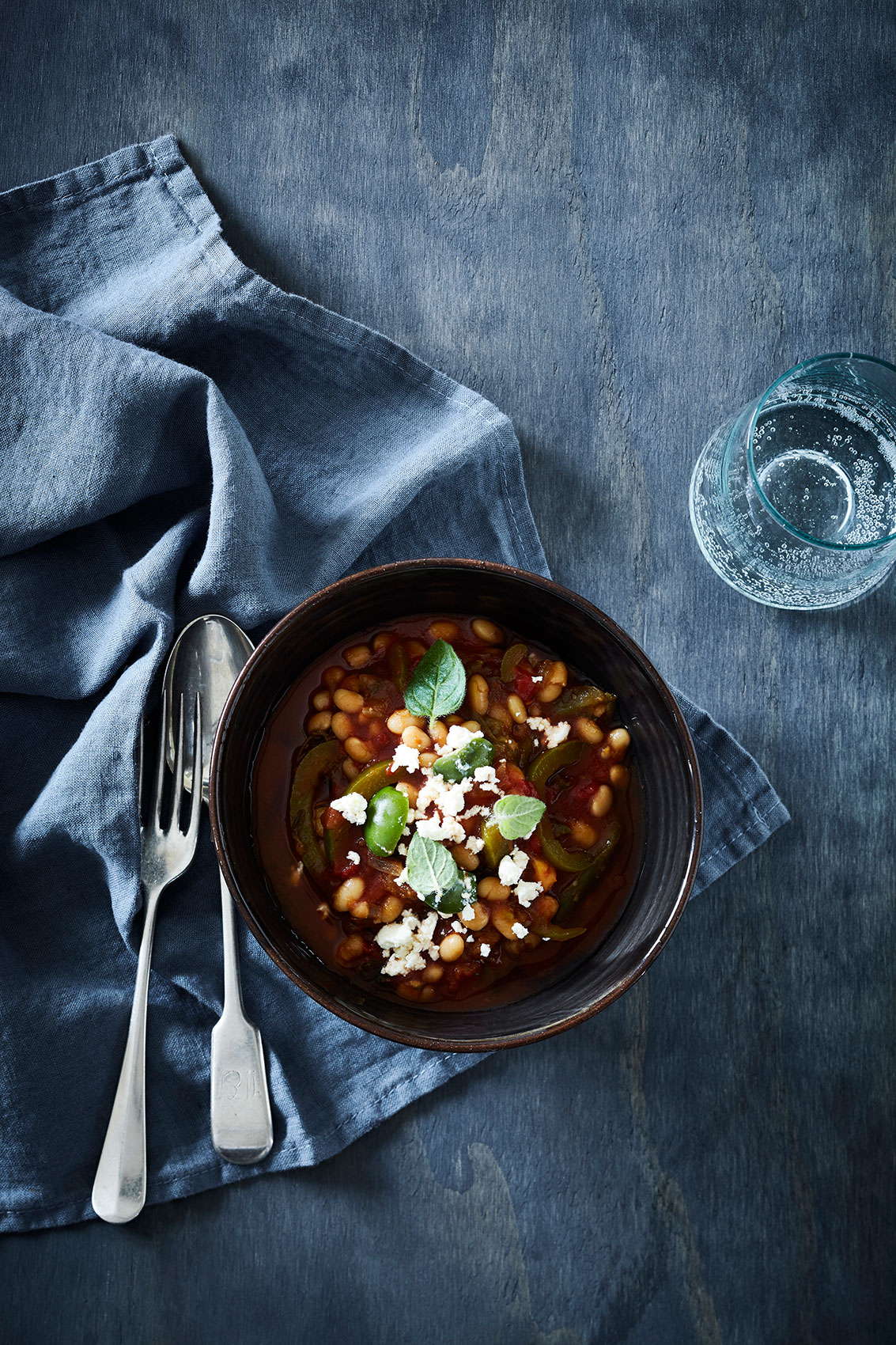 Slow Cooked • Spanish Beans with Goat Cheese & Mint in Dark Bowl • Cookbook & Editorial Food Photography