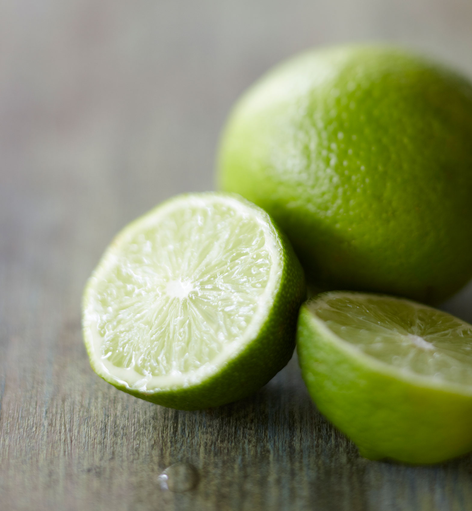 Everyday • Freshly Cut Green Limes on Dark Wooden Bench • Hospitality & Editorial Food Photography