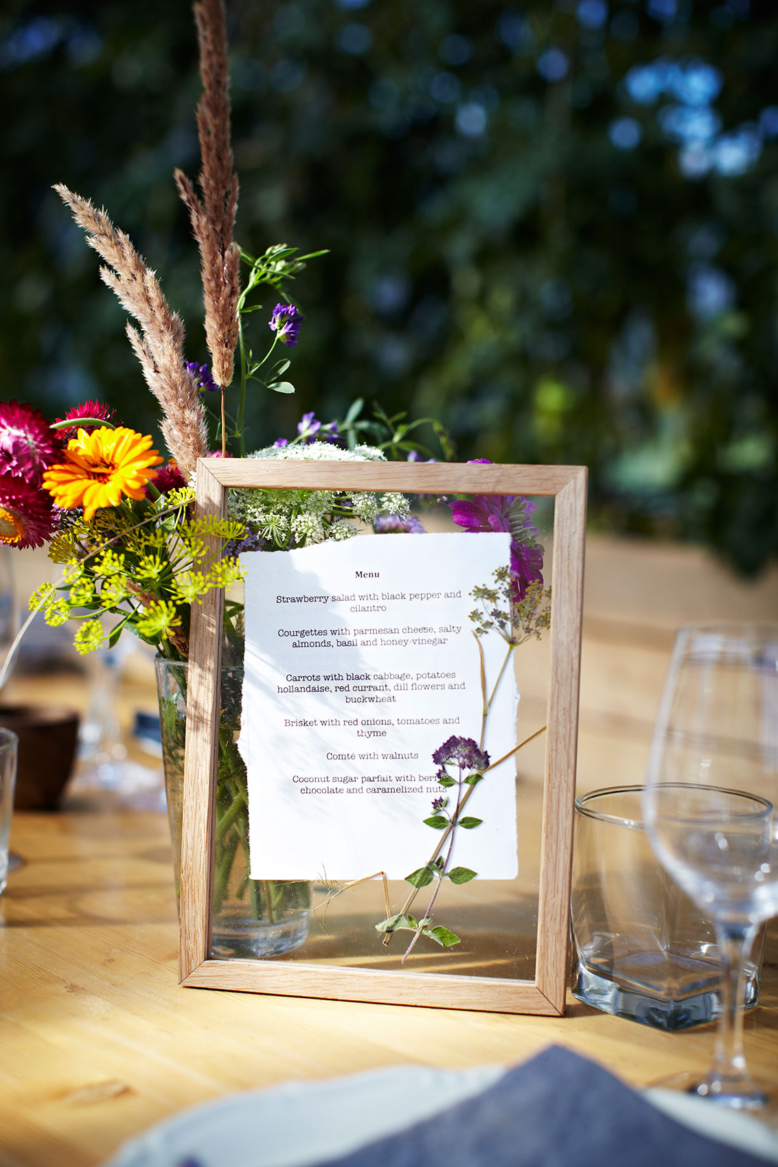 Stedsans in the Woods • Outdoor Lunch Menu in Glass Frame with Wild Flowers • Lifestyle & Editorial Food Photography