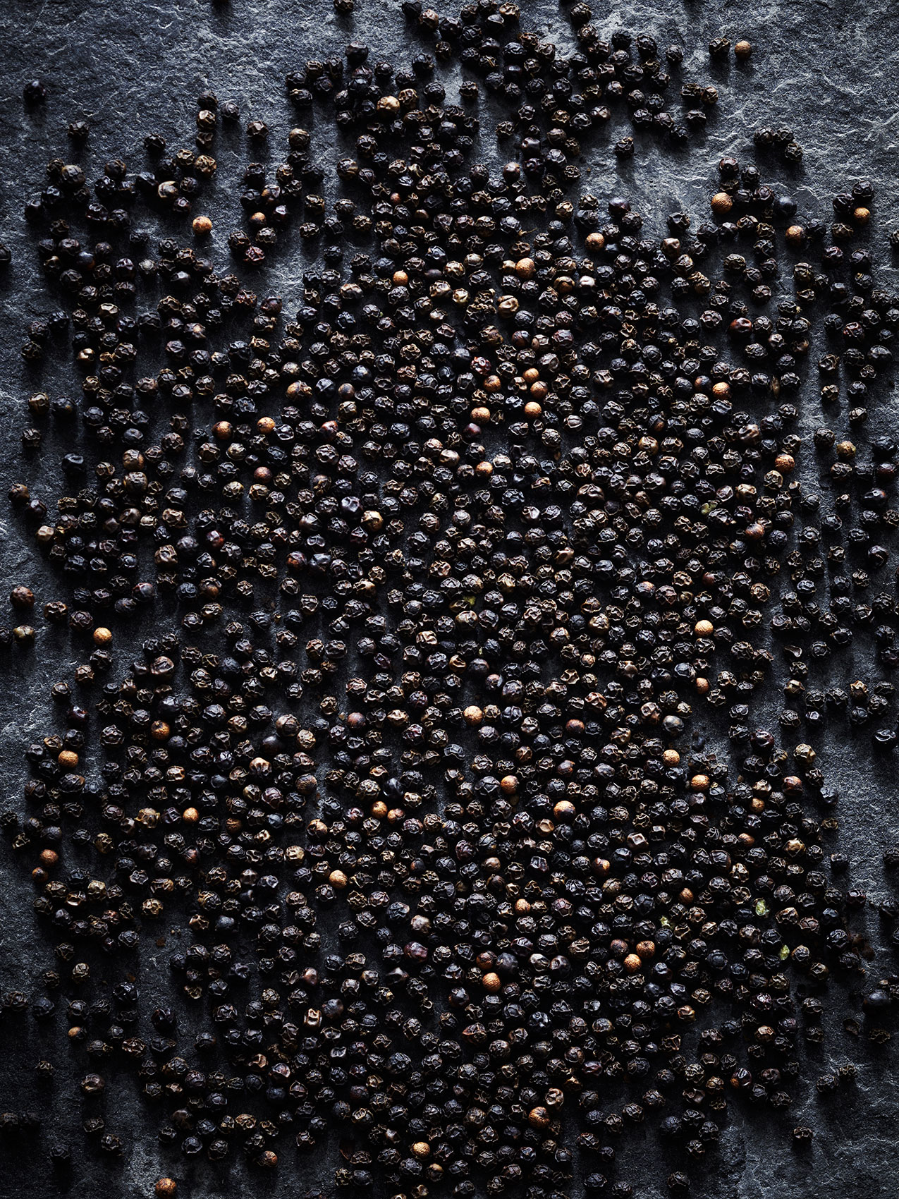 Spice Health Heroes • Dried Black Peppercorns on Dark Textured Table • Cookbook & Editorial Food Photography