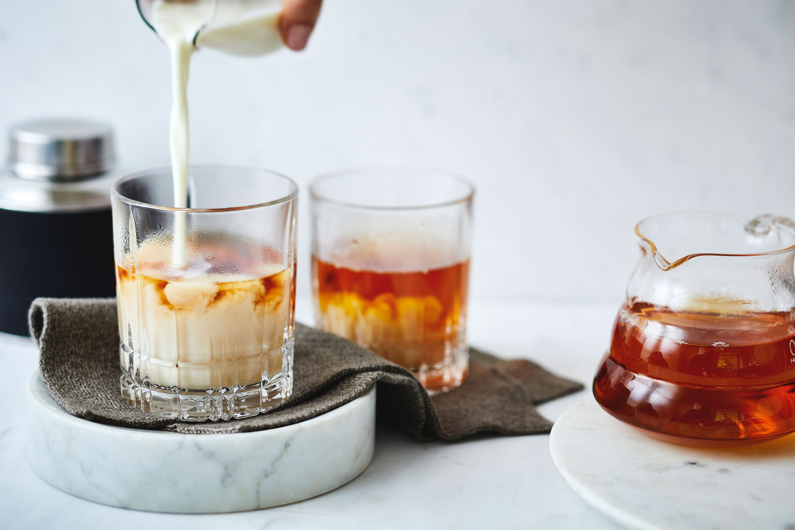 Fresh Milk Poured Over Black Tea in Whiskey Glass • Beverage & Liquid Photography